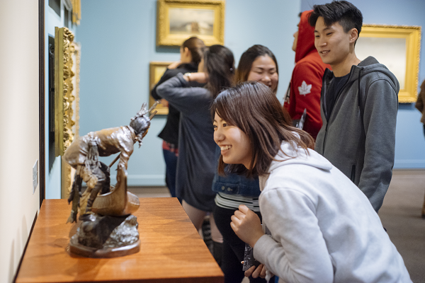 Woman looking at small sculpture on table