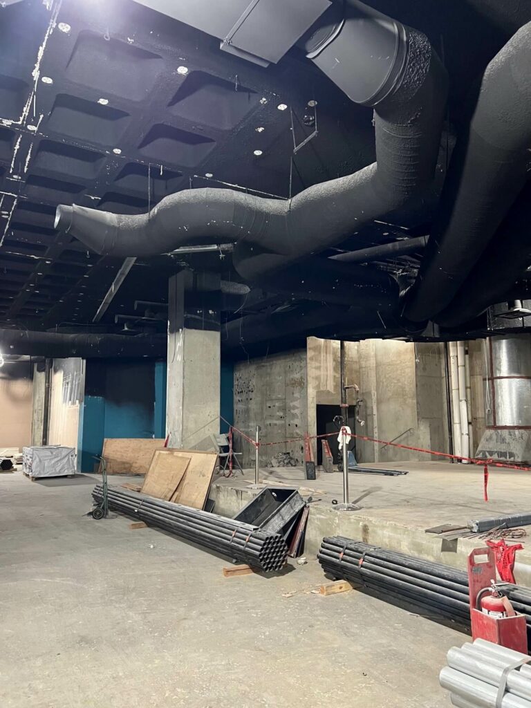 A demolished gallery, exposing the original ductwork and interior structure.