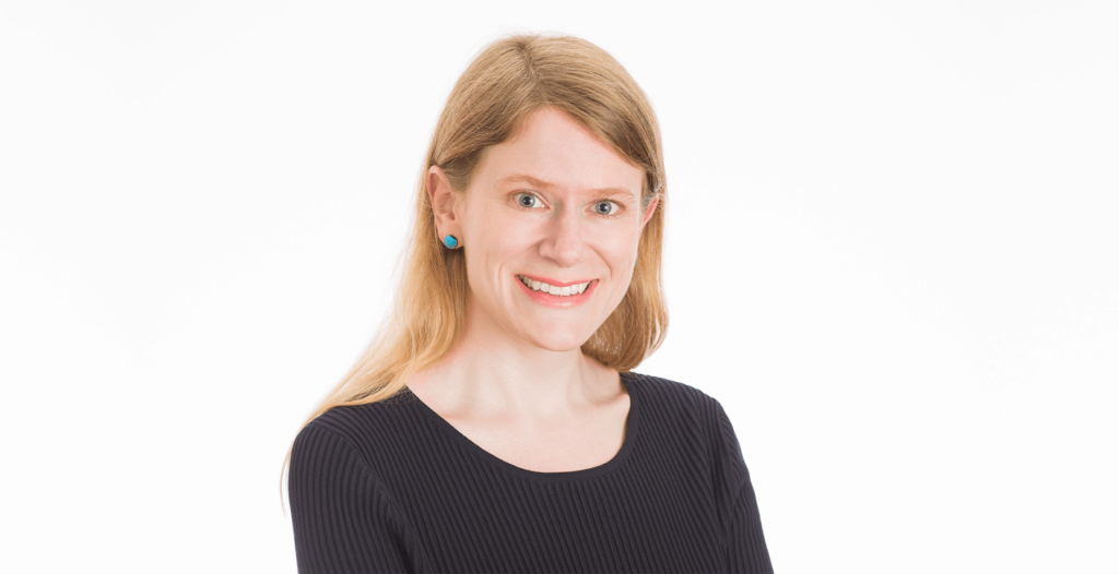 Dr. Jocelyn Anderson smiles in a portrait. She has light-colour, shoulder-length hair and is wearing a dark shirt.