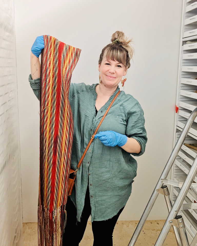 Artist Tegan Whitesel holding a Métis sash, date unknown, Collection of Glenbow.