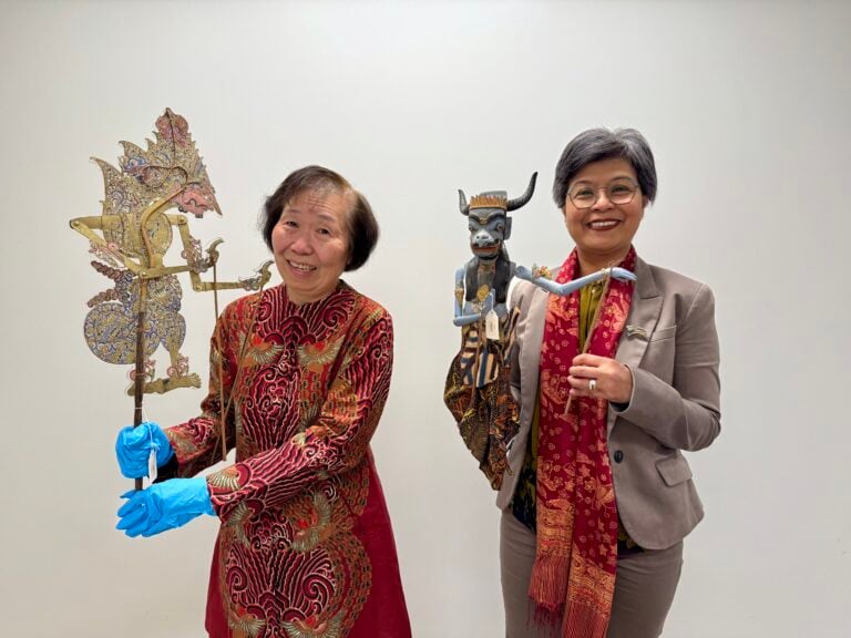 Cindy Halim and Ratna Wynne hold Indonesian puppets in Glenbow’s collection.