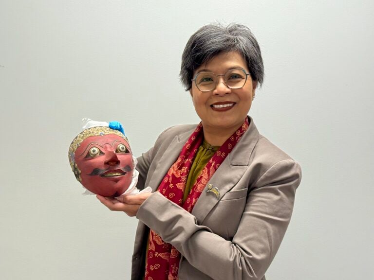 Ratna Wynne holds an Indonesian mask in Glenbow’s collection.