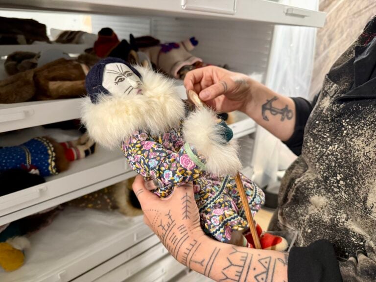 Sarah Whalen-Lunn holds a doll made by artist Susie Evaglok in Glenbow’s collections.