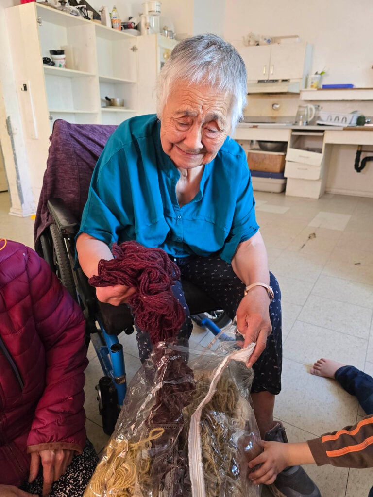 A woman shows darkly coloured natural dye wool