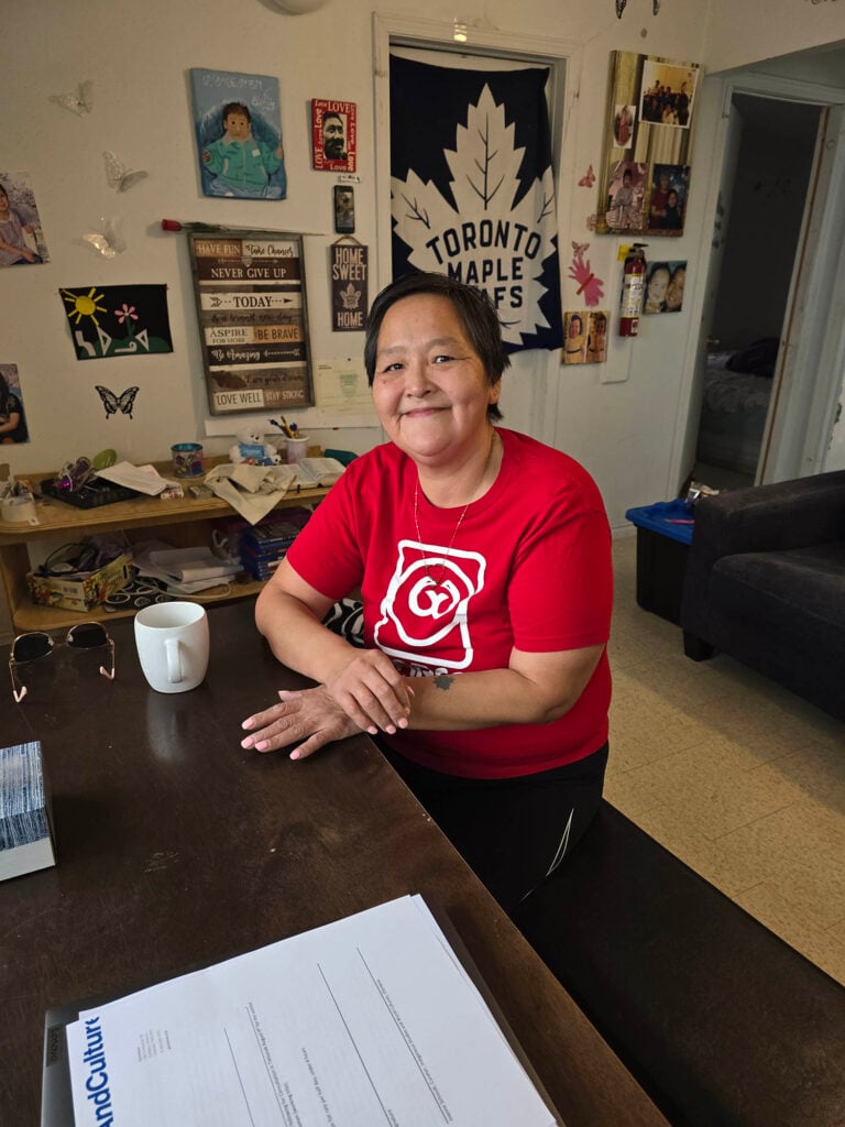 A woman smiles at the camera while sitting at a table
