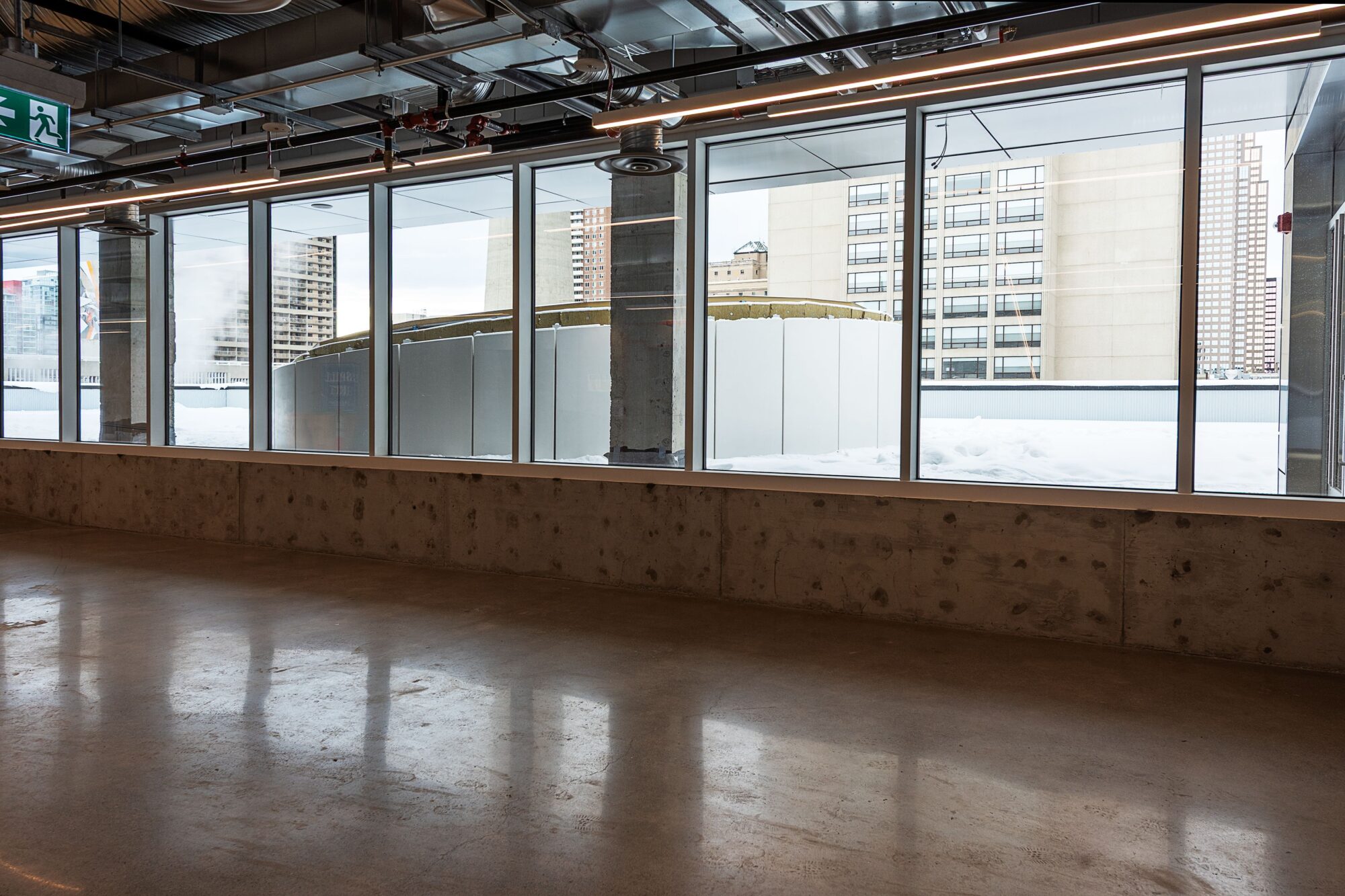 A window looking out at a rooftop terrace under construction.